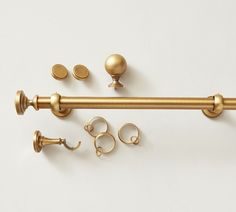 an assortment of brass hardware and knobs on a white background