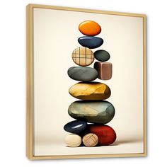 a stack of rocks with an orange and black ball on top in front of it