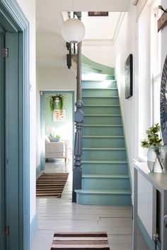 a hallway with blue stairs and white walls