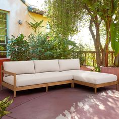 a couch sitting on top of a patio next to a tree