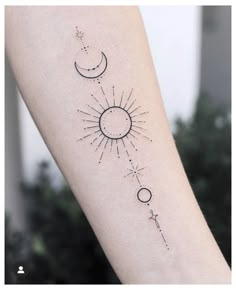 a woman's arm with a sun and moon tattoo on it