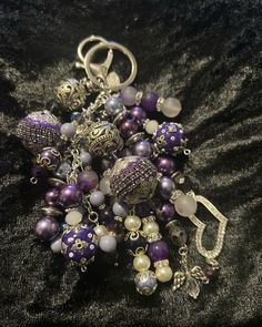 a bunch of beads that are laying on a black cloth with some charms attached to them