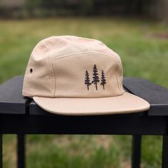 🌲🌲 5% of profits donated to preservation 🌲🌲  Gear up for your next adventure with our sun 5 panel hat, the ultimate camp hat! Crafted from 100% cotton, this hat's flat bill keeps you cool and shaded as you conquer trails, lounge by the campfire, or explore the great outdoors. Your new adventure-ready essential! This hat is khaki/tan with black embroidered trees on the front. Embroidery is custom designed by the shop owner, Alyssa, stitched on front. - 100% cotton - 5 Panel, Camp Hat - Head circumference: 19⅝″-22½″ - Flat Bill - Nylon adjustable strap - Custom embroidery, on the front center - Hand wash, dry flat - The perfect hiking gift, camping gift and nature gift! Embroidered Trees, Olive Green Hat, Camper Hat, Camp Hat, Five Panel Hat, Hiking Hat, Tan Hat, Flat Brim Hat, Five Panel