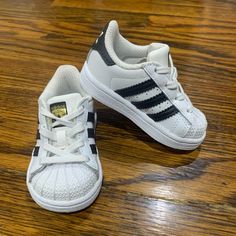 Brand New, Never Used. Unisex Sneakers Toddler Size 4. White W/ Black Stripes. Hard Bottoms Infant Adidas Shoes, White Scratch-resistant Sneakers For Spring, Spring Scratch-resistant White Sneakers, Spring White Scratch-resistant Sneakers, White Scratch-resistant Sneakers For Playtime, Girls Tennis Shoes, Toddler Adidas, Adidas Super, Adidas Baby