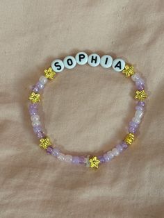 A hand-crafted glass bead friendship bracelet highlighting the Katseye group member, Sophia! Show your love for your favorite new group and bias with this cute accessory!  This bracelet is made with Czech glass beads, plastic letter beads, plastic spacer beads, and is on an elastic thread measured at about 10 inches in length for a relaxed/loose fit. If you would like the bracelet you order to be smaller or larger, please leave the requested size in inches in the personalization box!  All bracelets are made to order and are typically shipped out within 1-3 business days unless otherwise stated. Cute Adjustable Letter Beads, Handmade Purple Name Bracelet With Round Beads, Adjustable Crystal Bracelet With Letter Beads For Friendship, Purple Beaded Charm Bracelet For Friendship, Cute Beaded Name Bracelet With Round Beads, Cute Round Beaded Bracelets With Letter Beads, Personalized Cute Beaded Bracelets, Purple Beaded Name Bracelet With Round Beads, Adjustable Purple Beaded Name Bracelet