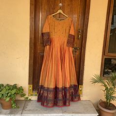 Traditional Anarkali suit usa / narayanpet dress / pure cotton kanchi handloom dress with big traditional border  /Handloom dresses / voggish / yellow  anarkali dress / cotton dress          Looking for a perfect indian dress/anarkali/suit sets that are trendy, unique and easy to carry !! yess, You are at the right place. we carry such versatile pieces of anarkalis and suit sets, kurtas that really let you stand out in any occassion !!      featuring this beautiful pure handloom kanchi cotton dress in dual tone orange color with traditional contrast borders with hand embroidery on the neck as shown !! A very classy, beautiful , traditional yet modern  , perfect and super comfy for any occasion !! Ready to ship , Can be customized in colors and patterns !! Pair it up with antique necklace/ Orange Contrast Colors Suit, Traditional Cotton Silk Maxi Dress, Bohemian Cotton Silk Dress With Traditional Drape, Traditional Long Sleeve Maxi Dress With Pallu, Traditional Long Sleeve Maxi Dress For Transitional Season, Transitional Cotton Dress With Resham Embroidery, Traditional Long Sleeve Transitional Maxi Dress, Eid Long Sleeve Dress With Cutdana Detailing, Bohemian Cotton Designer Dress