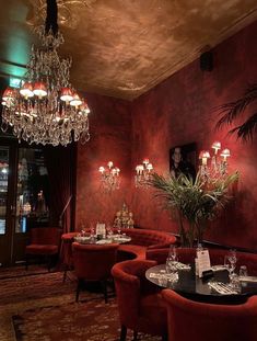 an image of a restaurant setting with red chairs and chandelier hanging from the ceiling