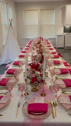 a long table set with pink and gold place settings