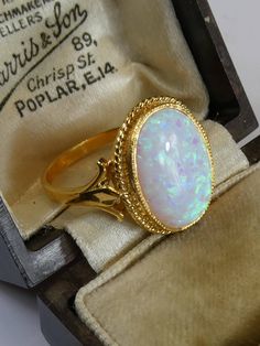 A fine silver with 18ct gold finish cutured opal ring. the opal has plenty of fire and is set in a simple rope twist mount . the front oval panel measures 1.6cm high x 1.3cm, ring size uk- o, usa 7.5. looks stunning when worn, uderstated but very classy. stamped 'sil' and has tested 925 silver and 18ct gold plated finish. Classic Oval Hallmarked Opal Ring, Antique Oval Opal Ring As Gift, Classic Gold Opal Oval Cabochon Ring, Gold Opal Ring Oval Cabochon, Classic Gold Opal Ring With Oval Cabochon, Gold Ethiopian Opal Ring With Oval Cabochon, Formal Hallmarked Oval Cabochon Opal Ring, Antique Oval Opal Ring, Heirloom Oval Opal Ring Hallmarked