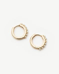 Fine Pearl Huggies 14k Solid Gold/Pearl. Everyday Huggies, Elevated. These Mini Hinged Hoop Earrings Feature White Cabochon Pearls. Pair with Diamond Studs for a Refined Ear Stack. The Size of this Earring is Best for Those with Smaller Lobes, or Perfect for Second or Third Piercings. Crafted from 100% Recycled Gold, and Hallmarked for Authenticity. Cultured Freshwater Pearls are Sourced by Our Responsible Jewelry Council Certified Suppliers. Every Pearl is Naturally Unique in Its Irregularity; Imperfections are Here to be Celebrated. Metal: 14Ct Recycled Solid Gold Gemstone: Pearl Dimensions: 11mm X 2mm Weight: 1. 57g this Piece is Handcrafted with Recycled Metal Elements to Help us Reduce Our Environmental Impact. Product Code: Fj-G-E26-Wp Pearl Huggies, Ear Stack, Freshwater Cultured Pearls, Recycled Metal, Recycled Gold, Environmental Impact, Gold Pearl, Diamond Studs, Freshwater Pearls