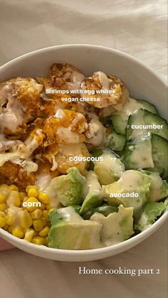 a white bowl filled with different types of food on top of a table next to a person's hand