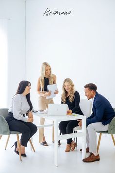 three women and two men sitting at a table with laptops in front of them