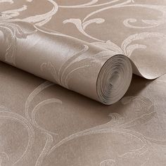 a roll of metallic foil paper on top of a wallpaper covered in an intricate design