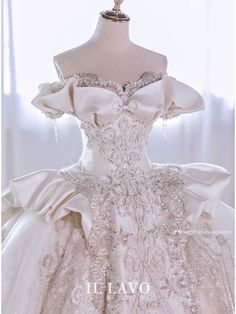 a wedding dress on display in front of a white background with the words elavo written