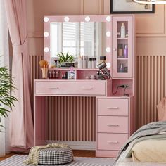 a pink vanity with lights on it in a bedroom