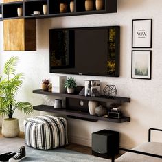 a living room with a large flat screen tv mounted to the wall and shelves above it