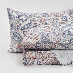 two pillow cases with blue and orange designs on them, one is folded over the other