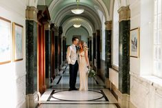 a bride and groom are standing in the hallway