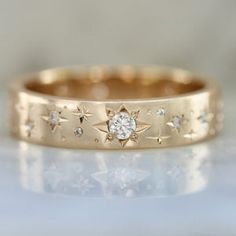 a gold ring with stars and diamonds on it