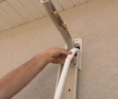 a person is fixing an electrical outlet on the wall with a pipe attached to it