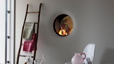 a room with a table, chair and fire in the fireplace on the wall behind it