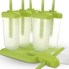 four green cups with toothbrushes in them