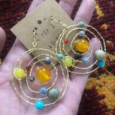 "Solar system celestial earrings are handcrafted from solid copper wire. Earring pendant approx. 2.25-2.5\" in diameter. Hangs from copper fish hook earring approx. 3-3.5\" long. Copper fishhooks are made by hand from solid copper wire which is hypoallergenic, easy to polish and nickel free. Polishing pad included. 💫 yellow Jade/ sun 💫 hematite / mercury 💫 rhodochrosite / Venus 💫 sodalite / earth 💫 jasper / mars 💫 agate/ Jupiter 💫 amazonite / Saturn with copper rings 💫 prehnite / Uranus Artsy Wire Wrapped Dangle Jewelry, Handmade Brass Artsy Jewelry, Handmade Artsy Brass Jewelry, Handmade Celestial Metal Earrings, Handmade Metal Celestial Earrings, Nickel-free Celestial Crystal Earrings, Wire Wrapped Metal Crystal Earrings, Wire Wrapped Round Metal Crystal Earrings, Wire Wrapped Round Crystal Earrings