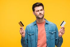 a man holding two credit cards in one hand and an empty card in the other