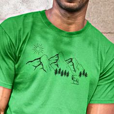 Looking for the Perfect T-Shirt to Wear on Your Next Adventure? Check out this mountain scene tee, it is the ideal fit for hikers, nature enthusiasts, campers, and vacationers. This shirt features a majestic mountain peak with beautiful pine trees that accent the base of the mountain. Additionally, a striking elk accompanies the mountain scene, adding a touch of the wild. The design wouldn't be complete without the bright sun shining down on it all, making it the perfect t-shirt for any outdoor excursion. Order now and let's explore the great outdoors together! This cotton tee is a versatile and comfortable choice for any wardrobe. It's made of 100%cotton and has a classic fit with no side seams for added comfort. The tear-away label makes it easy to customize with your own design. The med Adventure Hiking, Bright Sun, Mountain Shirt, Hiking Gifts, Sun Shining, Mountain Peak, Summer Camping, Mountain Scene, Summer Tee