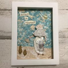 a white frame with a seashell in it and the words believe in yourself above it