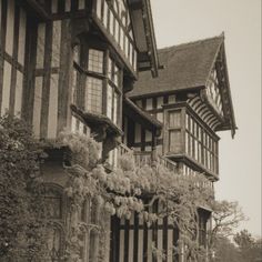 black and white photograph of an old house with ivy growing on it's balconies