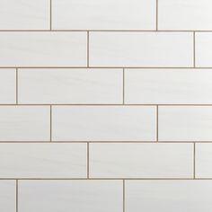 a white brick wall with gold lines on it