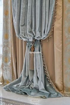 a curtain with tassels hanging from it's side in front of a window