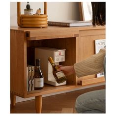 a person opening a wine bottle in a wooden cabinet