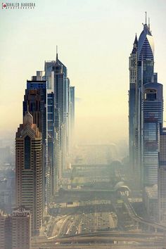 an aerial view of some very tall buildings in the middle of a large city with lots of traffic