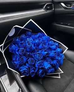 a bouquet of blue roses sitting in the center console of a car