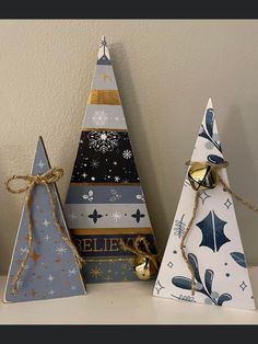 three wooden christmas trees with bells on them