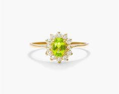 14K Yellow Gold Oval Halo Peridot and Diamond Ring (6.0x4.0mm). Emphasize the brilliant color of peridot with the natural beauty of round-cut diamonds. A bezel set floral halo around the center stone offers a modern look in a truly timeless setting. Peridot Rings, Sunburst Ring, Floral Halo, Colored Engagement Rings, Peridot Ring, Put A Ring On It, Round Cut Diamond, Diamond Shapes, Fashion Rings