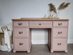 a pink desk with drawers and a vase on top that says hello written on it