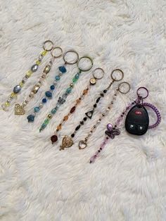 a bunch of key chains laying on top of a white blanket