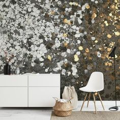 a living room with white furniture and gold foil wallpaper on the walls, along with a rug