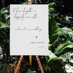 an easel with a sign on it in front of some plants