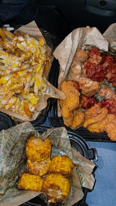 three trays filled with different types of food on top of a blue table cloth