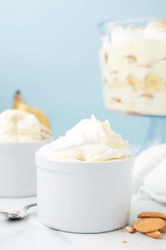 two white bowls filled with whipped cream and almonds