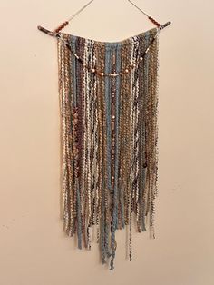 a wall hanging with beads and chains on it