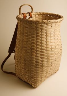 a woven basket with leather handles on the handle is shown in front of a white background