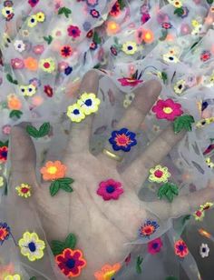 a person's hand with flowers on it