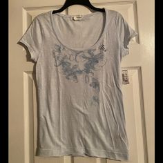 Aeropostale Light Blue T-Shirt With Flower Design (Size L) Light Blue Graphic Tee For Spring, Light Wash Short Sleeve T-shirt For Spring, Light Blue T Shirt, Orange Tees, Aeropostale Shirts, Camo Tee, Blue T Shirt, Blue T, Grey Shorts