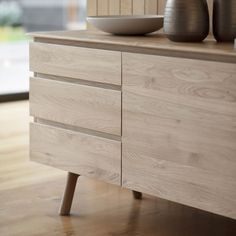 two vases sitting on top of a wooden dresser