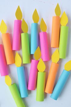 several different colored candles are arranged in the shape of firecrackers with yellow ones